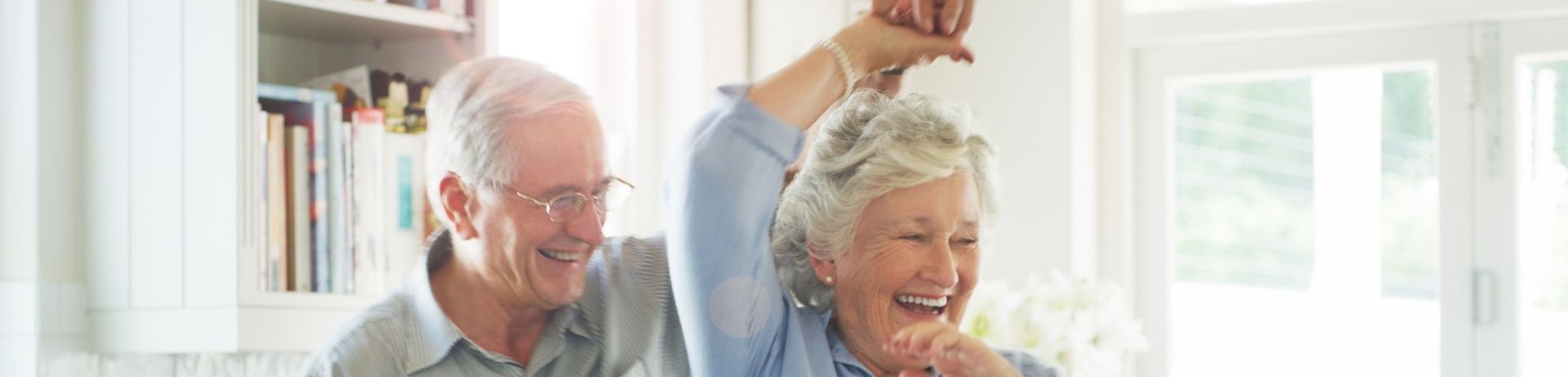 Senior couple dancing in their home