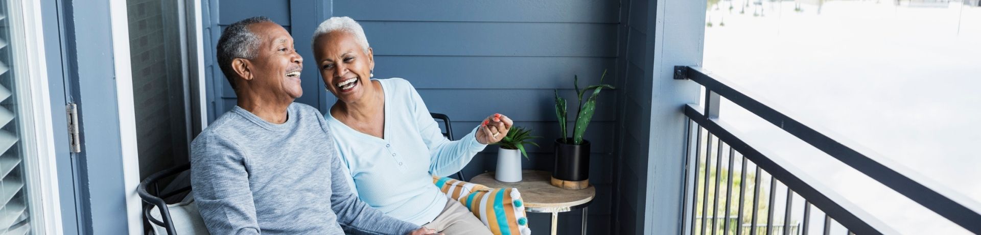 Senior couple laughing on the balcony